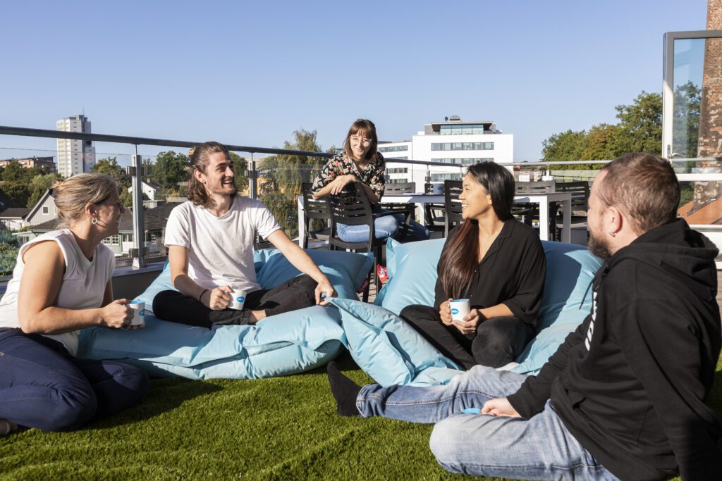 A group of young people sitting on a balcony talking and having fun.