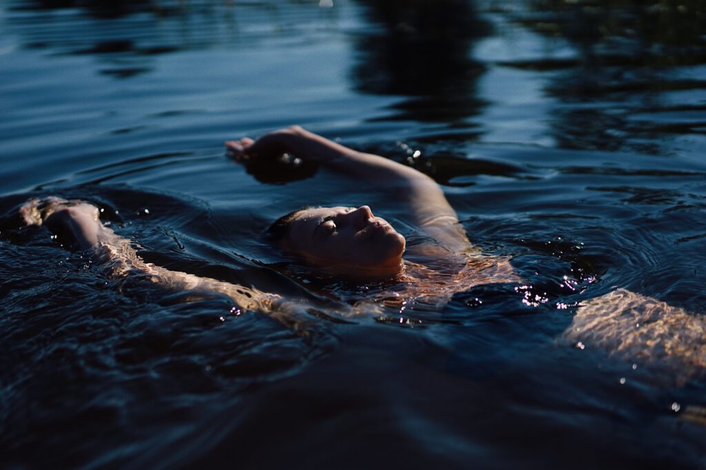 En kvinna ligger på rygg i en bassäng