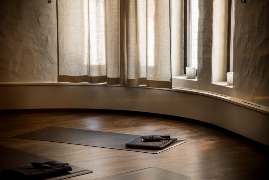 Ett rum med fönster och yogamattor på golvet