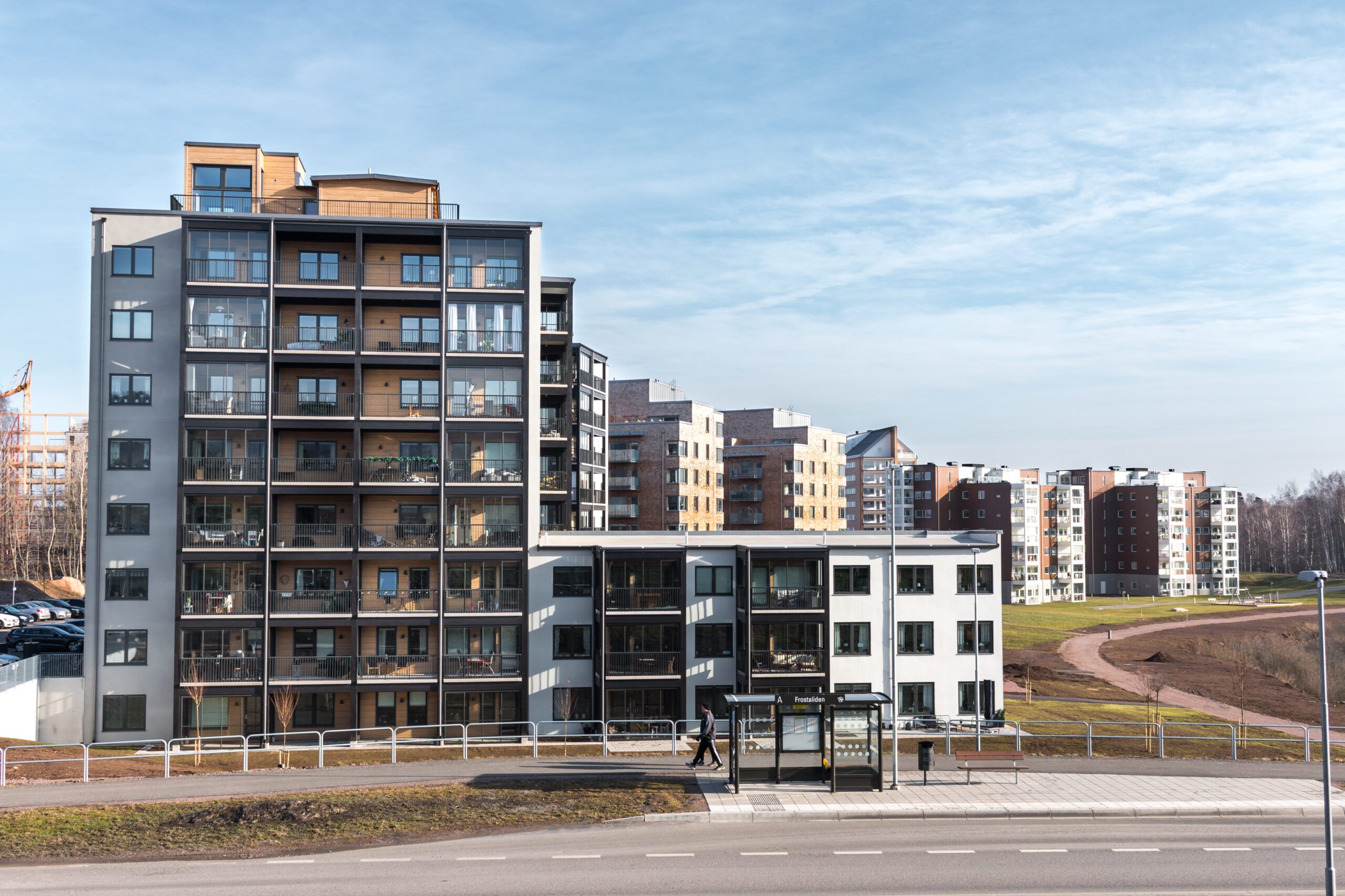 Ett höghus med flera balkonger med glasräcken.