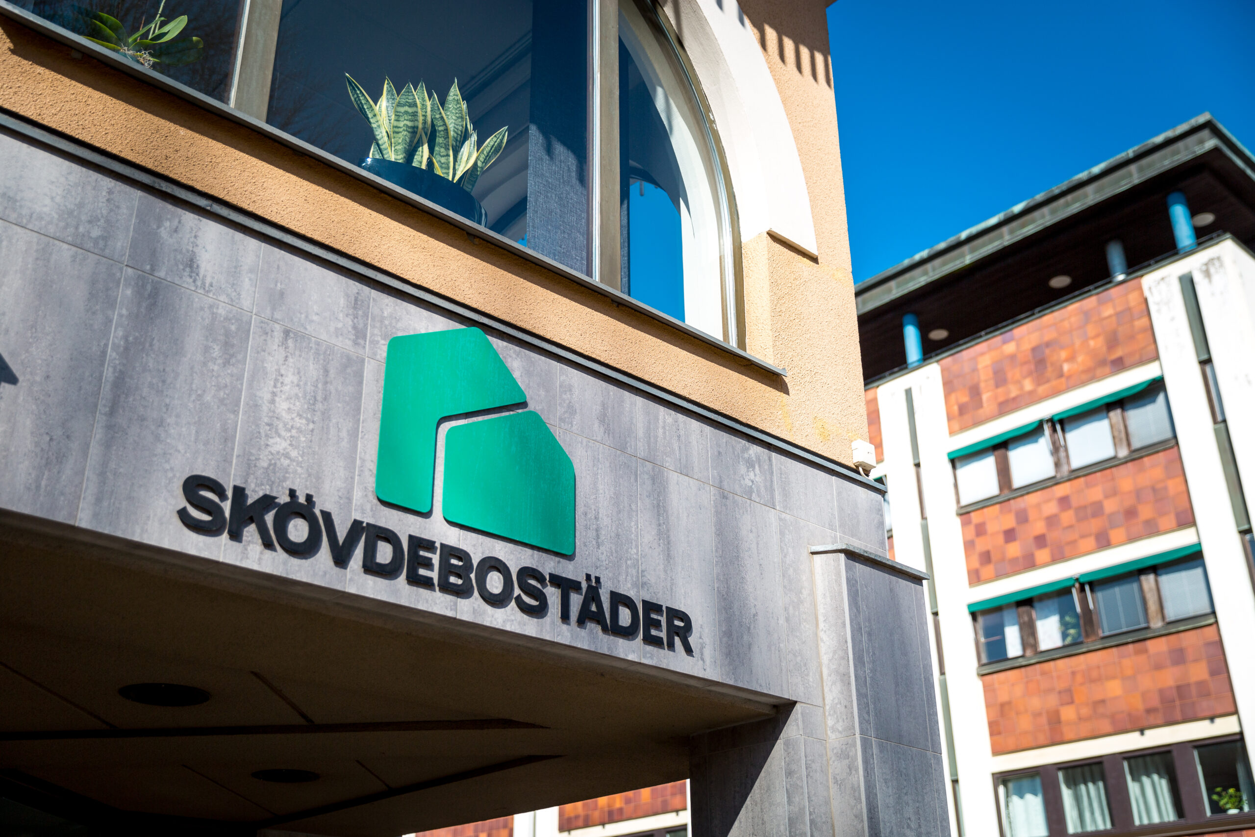 En fasad med en logga och en skylt med texten Skövdebostaäder