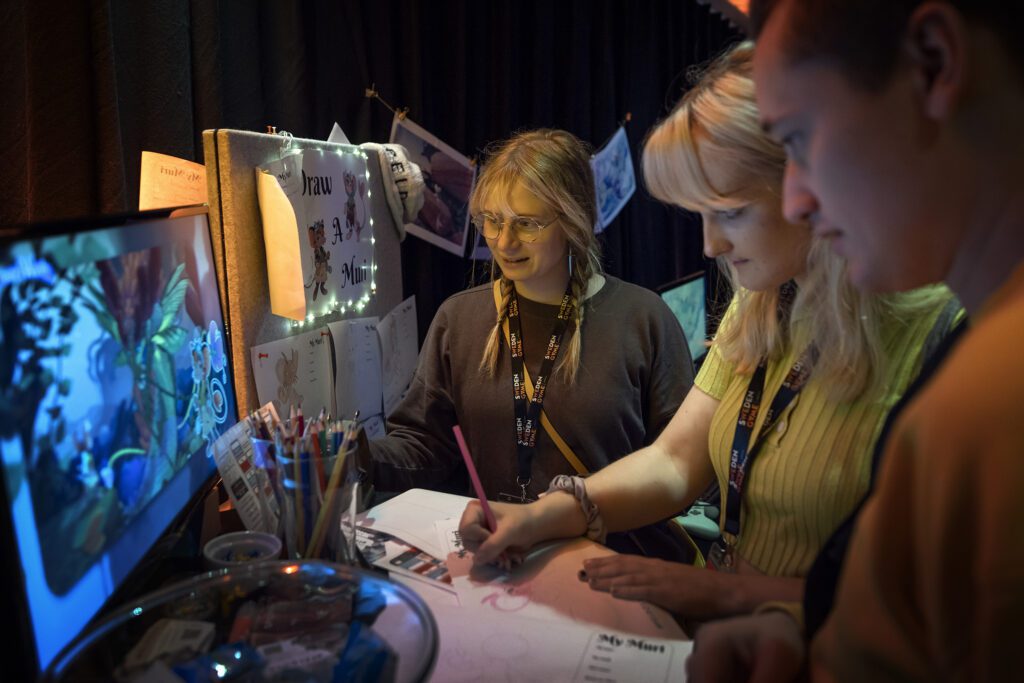 Two women stand at a desk and sketch on a piece of paper. The gaming industry in Skövde.