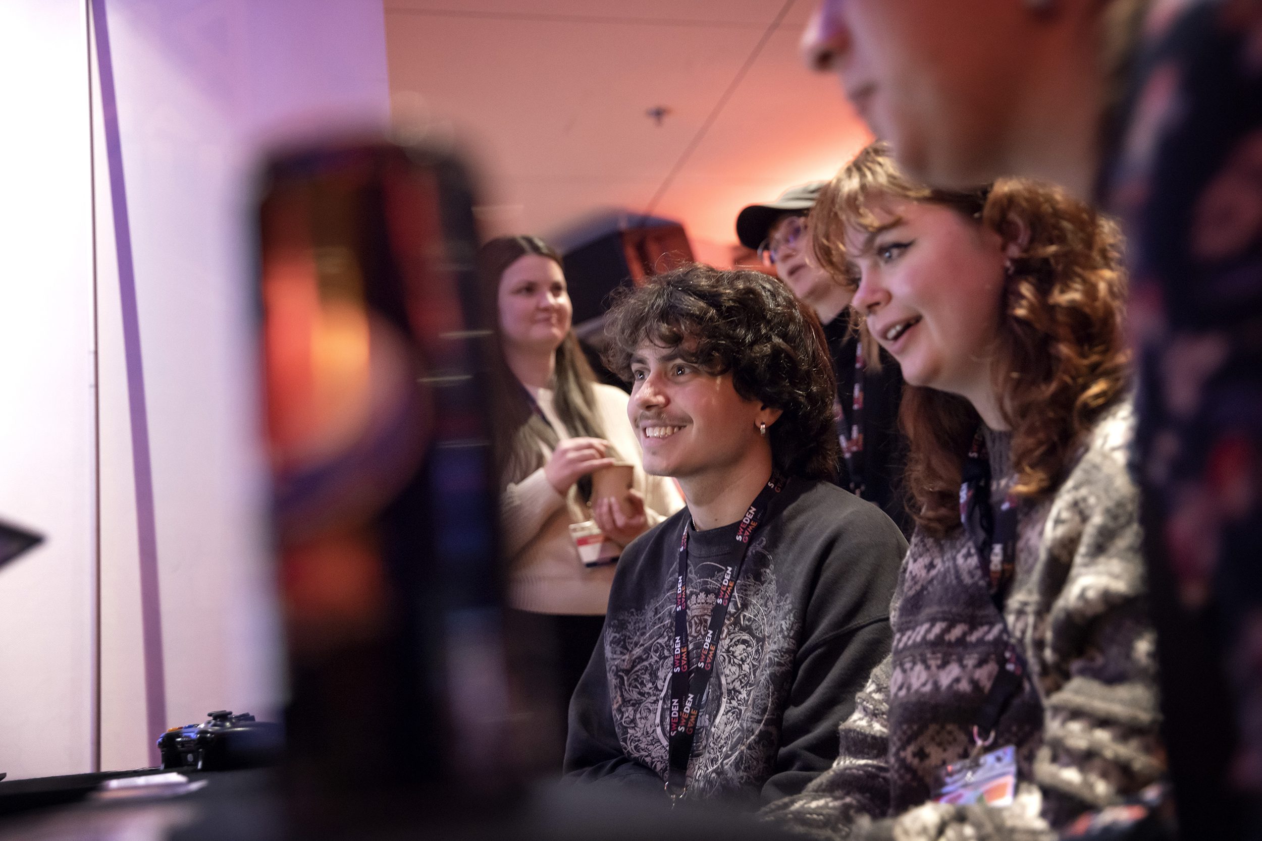 Some people sit and look at a computer screen together. Gaming industry Skövde