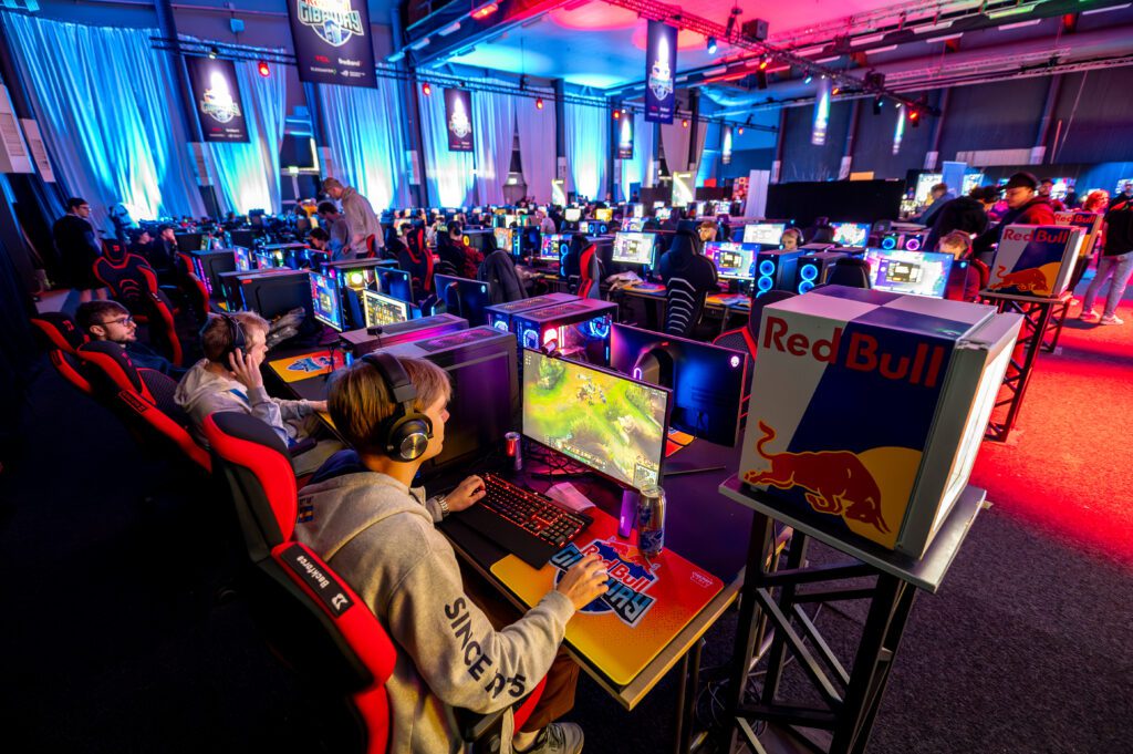 Några personer sitter i ett rum och spelar dataspel